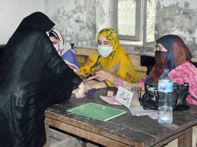 a kashmiri woman giving thumb impression on ballot paper at polling station during ajk legislative assembly elections 2021 photo app